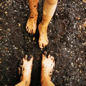 Zwei Paar Füße die mit Schlamm und Moor bedeckt sind. 