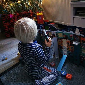 Ein Junge spielt mit seinen Weihnachtsgeschenken.